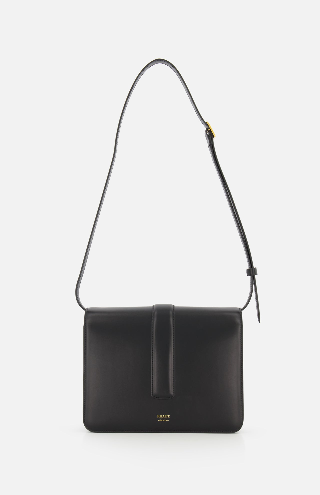 The KHAITE Blake Leather Crossbody Bag showcases Italian craftsmanship in black leather, a rectangular shape, adjustable strap, and front flap. "KHAITE" is embossed in gold at the bottom center, set against a plain white background.