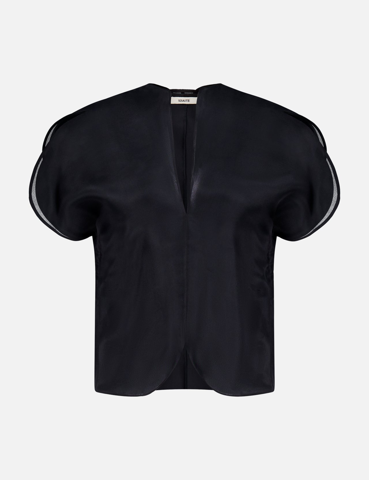 The KHAITE Briar Notch Neck Silk Blouse, featuring a black hue with short, rounded structured sleeves and a deep V-neckline, epitomizes quiet luxury. Expertly crafted in Italy from lustrous satin silk, it is showcased elegantly against a plain white background.