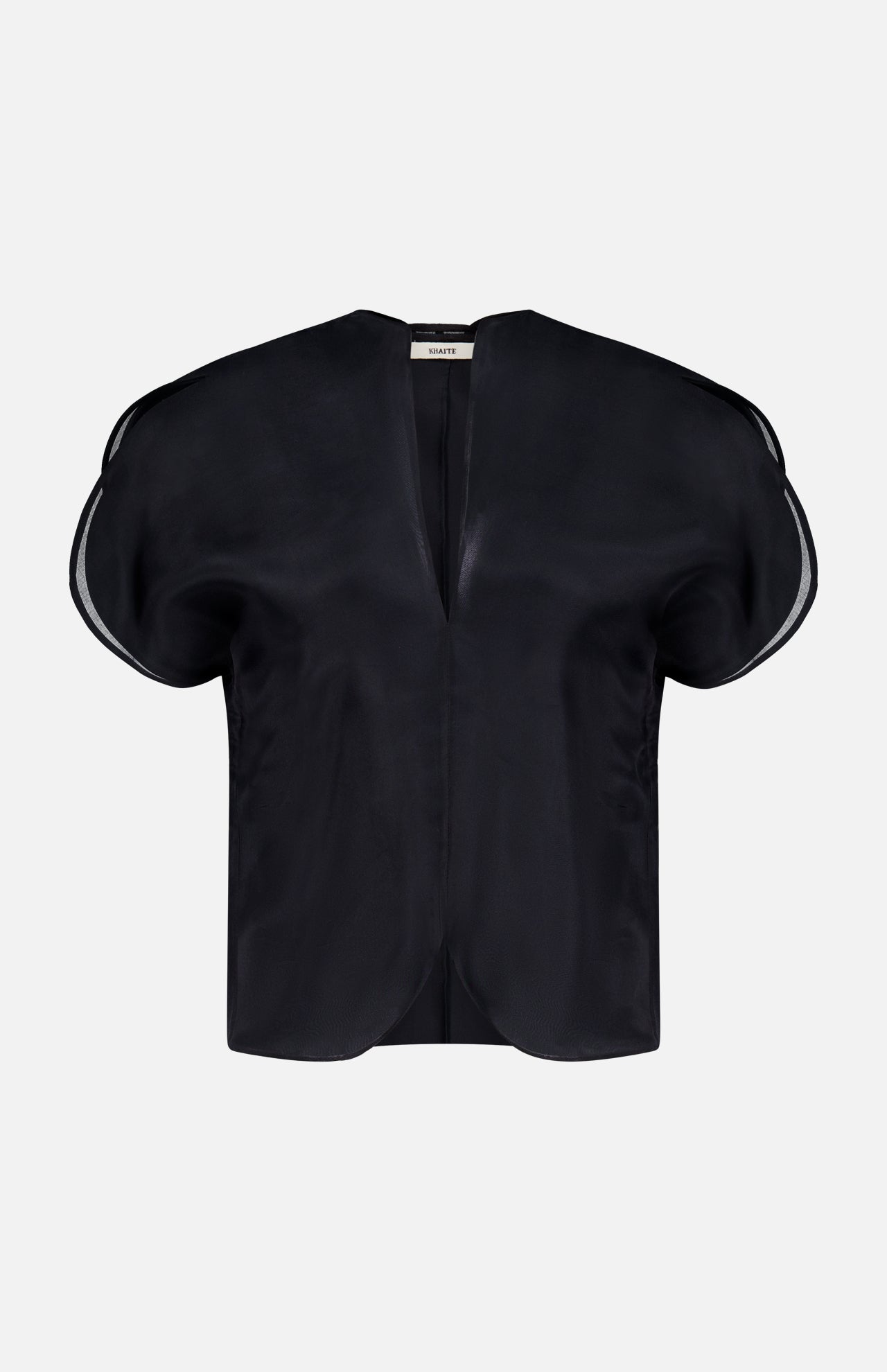 The KHAITE Briar Notch Neck Silk Blouse, featuring a black hue with short, rounded structured sleeves and a deep V-neckline, epitomizes quiet luxury. Expertly crafted in Italy from lustrous satin silk, it is showcased elegantly against a plain white background.