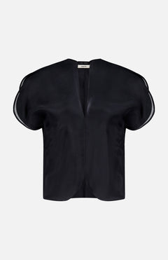 The KHAITE Briar Notch Neck Silk Blouse, featuring a black hue with short, rounded structured sleeves and a deep V-neckline, epitomizes quiet luxury. Expertly crafted in Italy from lustrous satin silk, it is showcased elegantly against a plain white background.