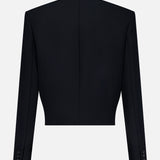 The Cord Embroidery York Jacket by KHAITE is showcased from the back in black, highlighting its long sleeves, straight hem, central back seam, buttoned cuffs, and a structured, tailored silhouette inspired by modern military design against a plain background.