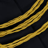 Close-up of the KHAITE Cord Embroidery York Jacket in black, featuring three thick, twisted yellow cords arranged across the chest in a style reminiscent of gold cord embroidery. A partially visible white KHAITE label with black text appears in the upper left corner.