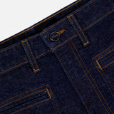 Close-up of the waistband and front pockets of the KHAITE Delmonico Wide Leg Jean in Benson, featuring high-waisted, dark wash denim with orange stitching, belt loops, and a metal button closure against a white background.