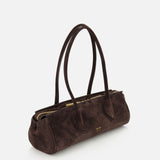 The KHAITE Donna Soft Handbag is a dark brown suede bag crafted in Italy, featuring two long straps, a gold zipper, and gold logo text on the front. It boasts a rectangular, structured silhouette with a minimalist and elegant design, photographed against a plain white background.