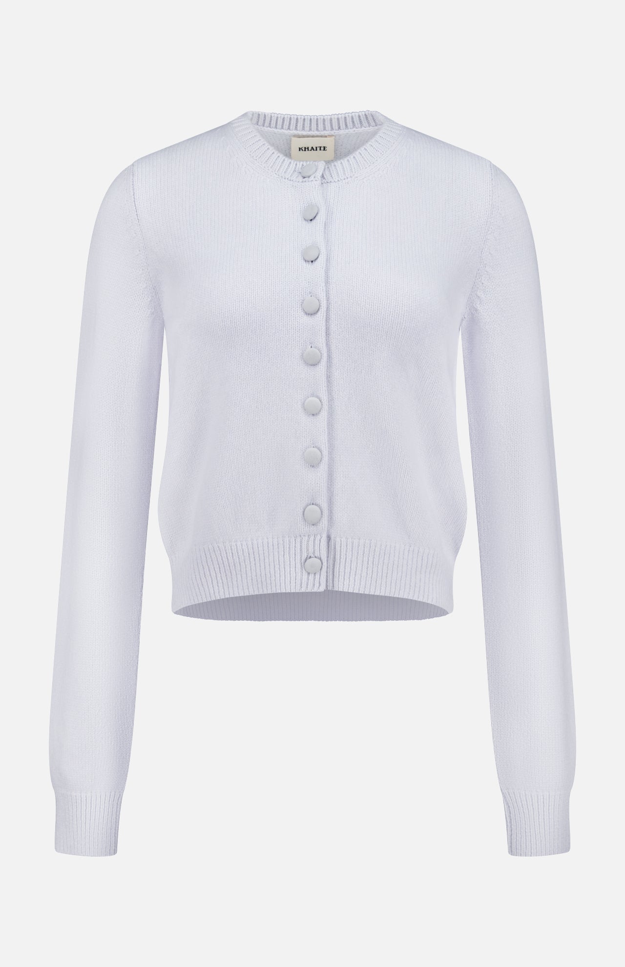 The KHAITE Everheart Suede Button Cardigan is a light purple, long-sleeved piece with a round neckline, ribbed details, and large matching buttons—ideal for a minimalist wardrobe.