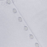 Close-up of the KHAITE Everheart Suede Button Cardigan in light blue, featuring a ribbed neckline, suede-covered buttons set diagonally, and the KHAITE label inside the collar—perfect for a minimalist wardrobe.