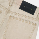Close-up of the back of the KHAITE Finley Jean in Dumas, featuring visible stitching, a large back pocket, belt loops, and a black leather patch with gold text. Crafted in stretch-free denim with a mid-rise cut for timeless style.