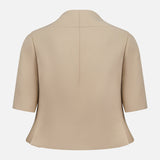 The KHAITE Folded Neck Franc Jacket, a beige tailored blazer with short sleeves in Italian crepe, is pictured from the back on a white background. Its clean center seam and structured fit suit any minimalist wardrobe.
