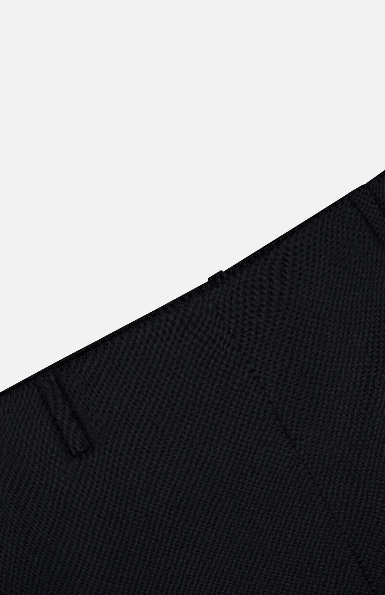 Close-up of the KHAITE Grenare Straight Leg Pant in black wool, laid flat on a light gray background. The image highlights the waistband, belt loop, and upper pant leg of these expertly crafted Italian trousers, designed for a refined and timeless tailored fit.