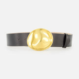 The KHAITE Keefe Dome Buckle Belt 35MM is a black leather belt made in Italy, featuring a large, shiny gold dome buckle, displayed against a plain white background.