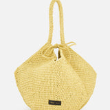 The Lotus Viscose Raffia Medium Bag by KHAITE is a yellow woven tote with two handles, a gathered drawstring top, and a small black rectangular label near the base. It’s crafted from sustainably harvested raffia.