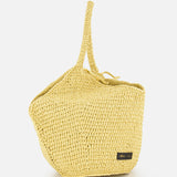 The KHAITE Lotus Viscose Raffia Medium Bag is a yellow Italian straw bag with a single top handle and a small black rectangular label on the front, displayed against a plain white background.