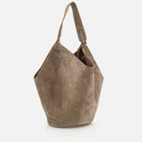 The KHAITE Lotus Medium Suede Tote Bag features taupe suede, a wide single shoulder strap, a soft slouchy geometric shape, and includes a removable pouch. Shown against a plain white background.