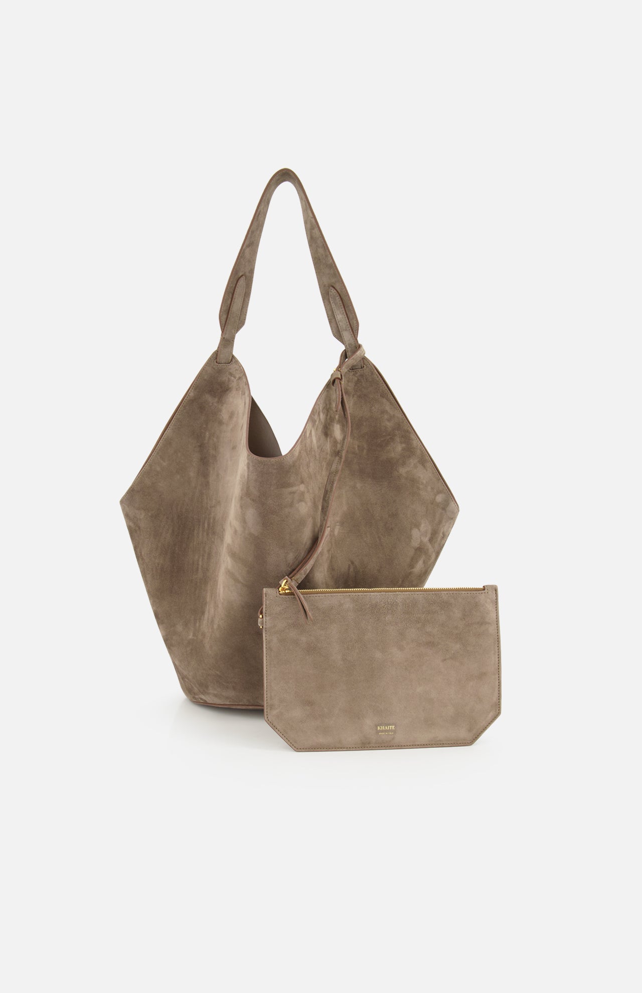 The KHAITE Lotus Medium Suede Tote Bag in taupe features two handles, a lightweight design, and a removable rectangular zippered pouch, all shown against a plain white background.