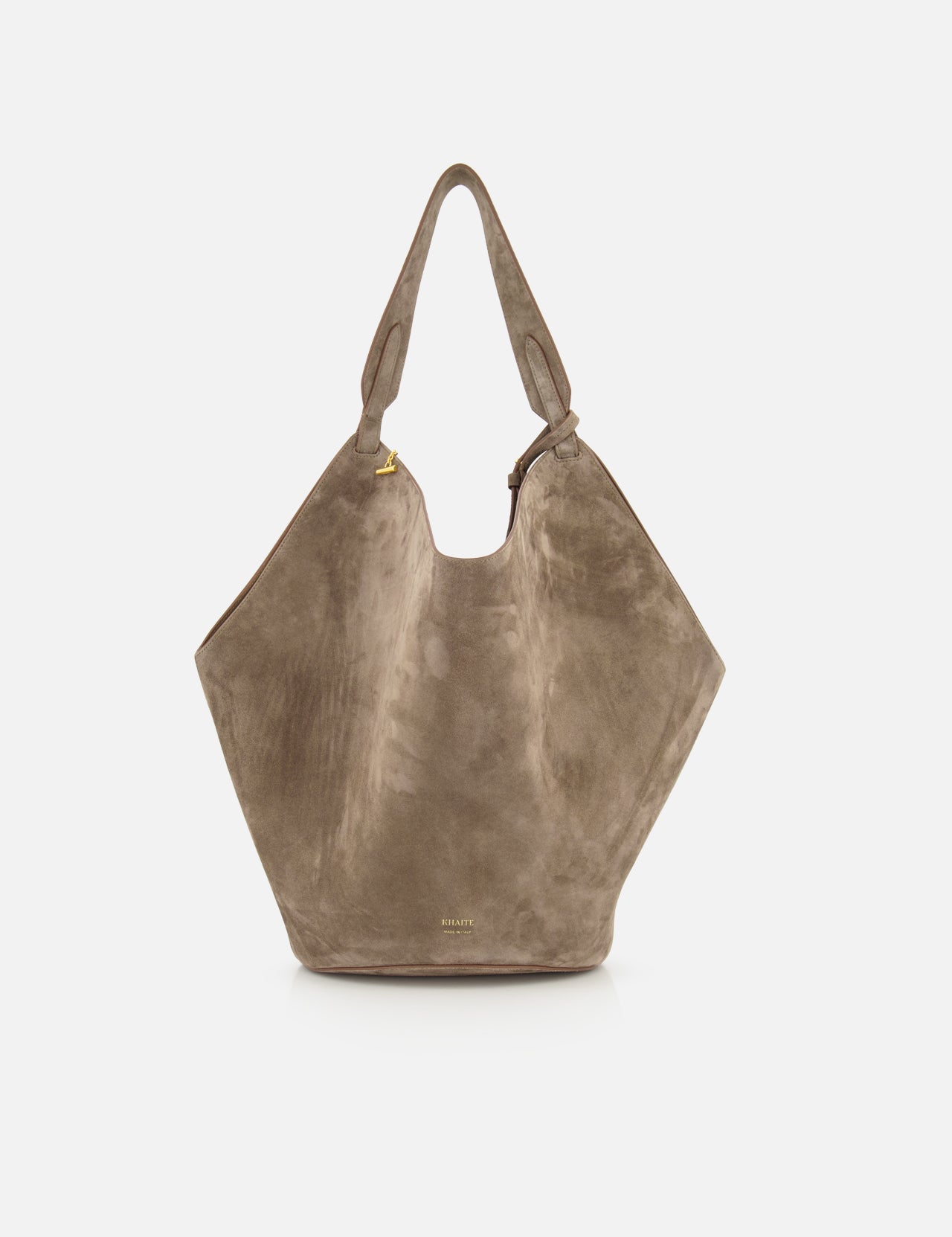 The KHAITE Lotus Medium Suede Tote Bag features a slouchy, geometric silhouette in lightweight taupe suede with a single wide shoulder strap, minimal gold hardware, removable pouch, and a subtle logo near the bottom.