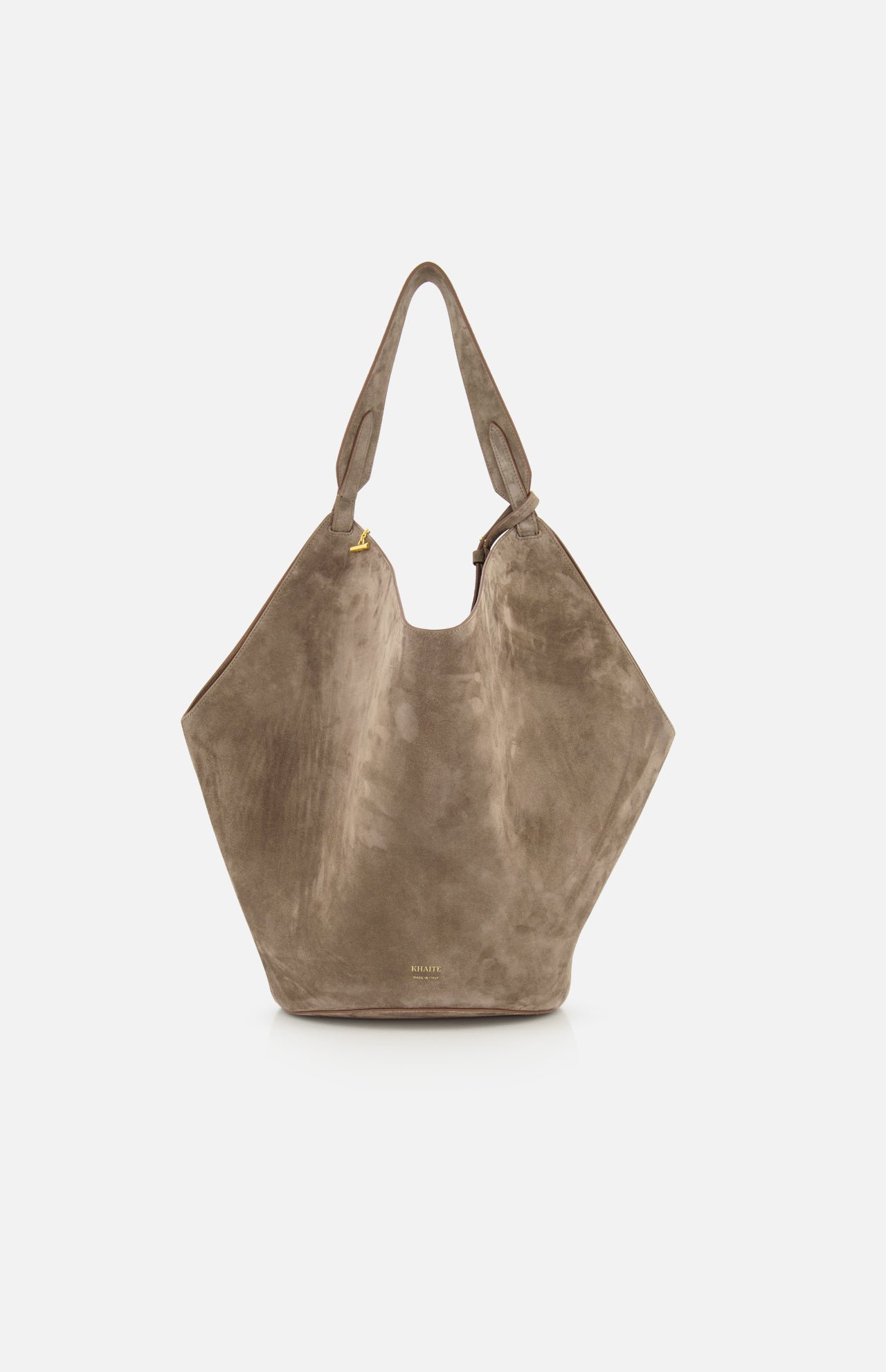 The KHAITE Lotus Medium Suede Tote Bag features a slouchy, geometric silhouette in lightweight taupe suede with a single wide shoulder strap, minimal gold hardware, removable pouch, and a subtle logo near the bottom.
