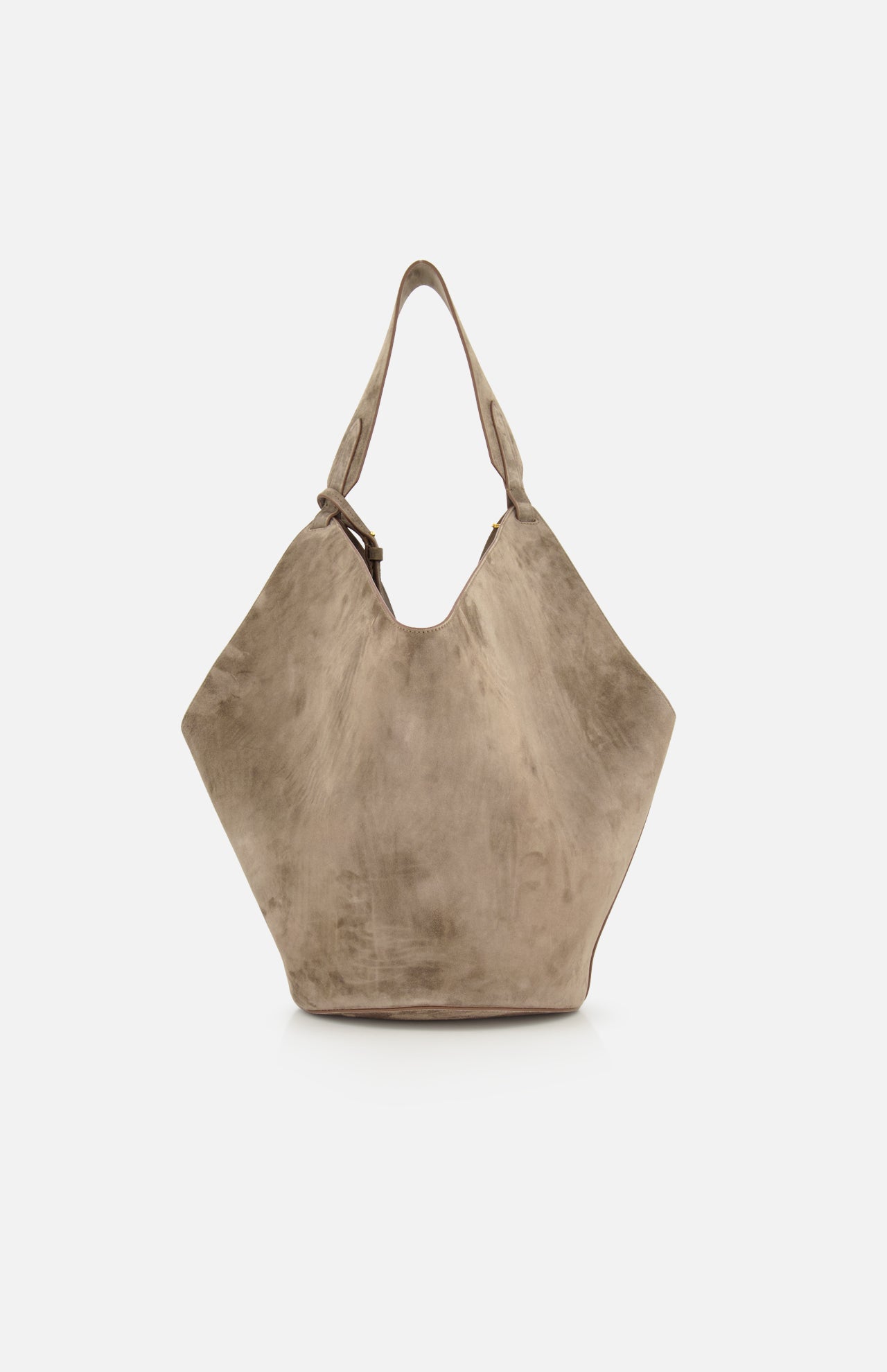 The Lotus Medium Suede Tote Bag by KHAITE is a large, lightweight taupe tote in suede, featuring a wide, angular shape, single top handle with decorative buckle, and a removable pouch. Displayed on a plain white background.