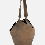 The KHAITE Lotus Small Tote Bag, crafted in Italy from distressed brown leather and featuring a single thick handle and distinctive sculptural shape, is the ideal accessory to elevate a minimalist wardrobe. It is shown here against a plain white background.