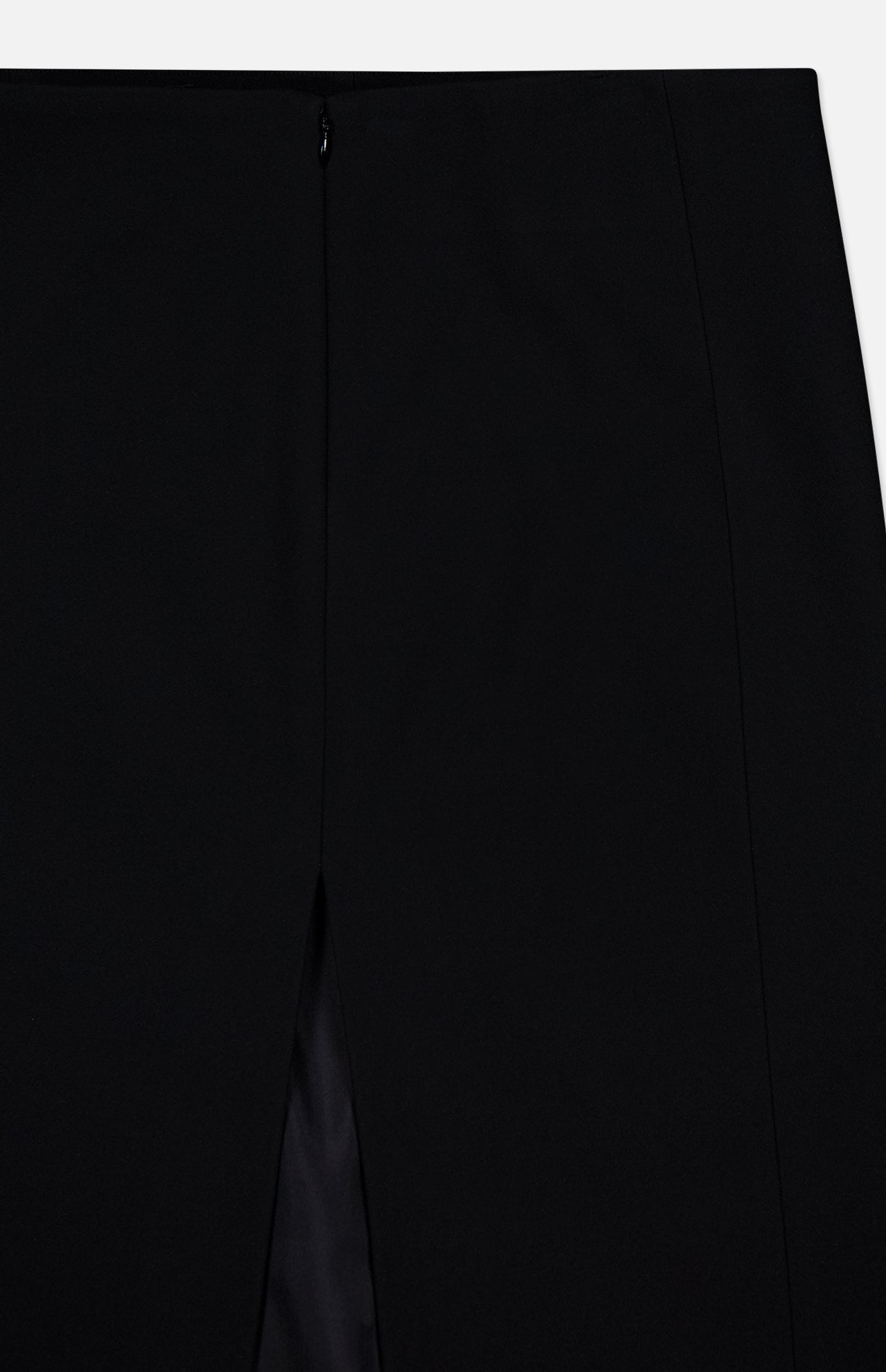 Close-up of the KHAITE Lyle Column Skirt, crafted in Italy in black with a center slit and small black button closure. Its smooth, tailored fabric and clean seams make it ideal for a minimalist wardrobe.