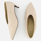 The KHAITE Miriam Glazed Leather Pump 50 is shown in nude leather, with one side view highlighting its slim pointed toe heel and another top view showing the minimalist insole—ideal for a sleek, modern wardrobe.