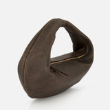 The KHAITE Olivia Hobo Medium Shoulder Bag is a crescent-shaped handbag in brown distressed leather, featuring a curved handle and a visible top zipper, displayed against a plain white background.