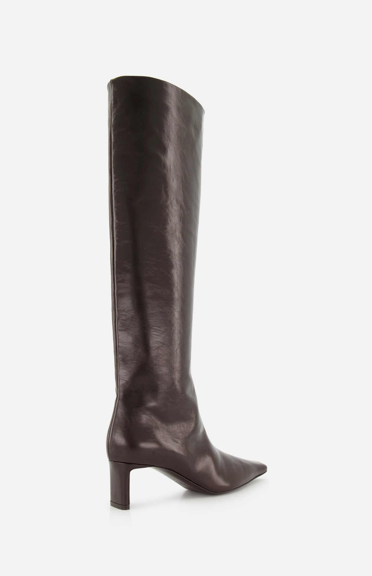 The Ona Knee High Boot by KHAITE is a tall, dark brown leather boot crafted in Italy, featuring a knee-high silhouette, pointed toe, and low block heel. The boot is displayed in side profile against a plain white background.