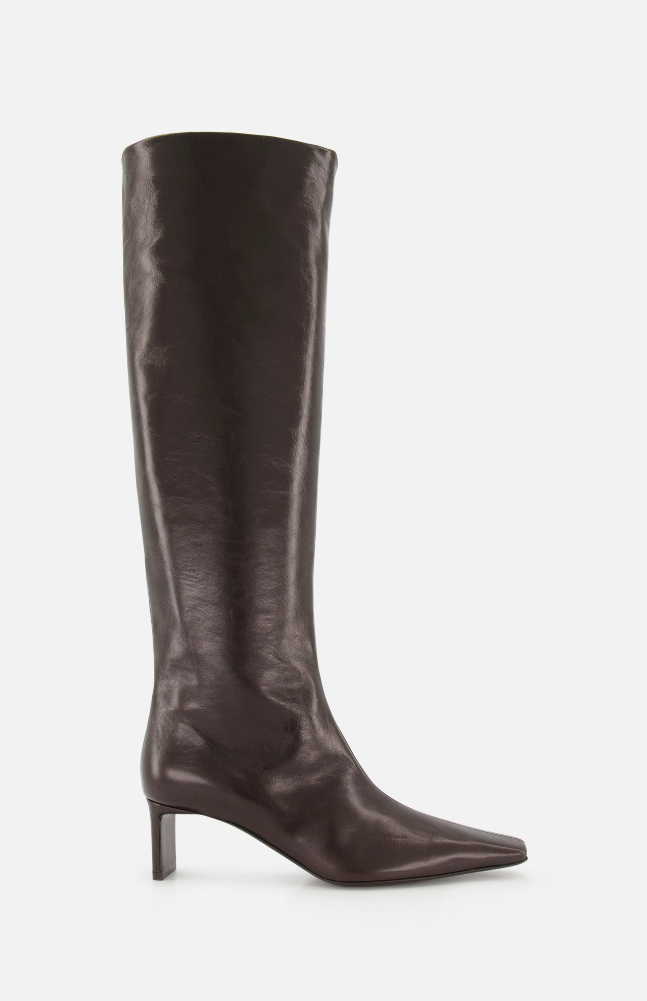 Introducing the Ona Knee High Boot by KHAITE: a tall, dark brown leather boot handcrafted in Italy, showcasing a knee-high silhouette with a pointed toe and a low, slender heel, photographed against a white background.