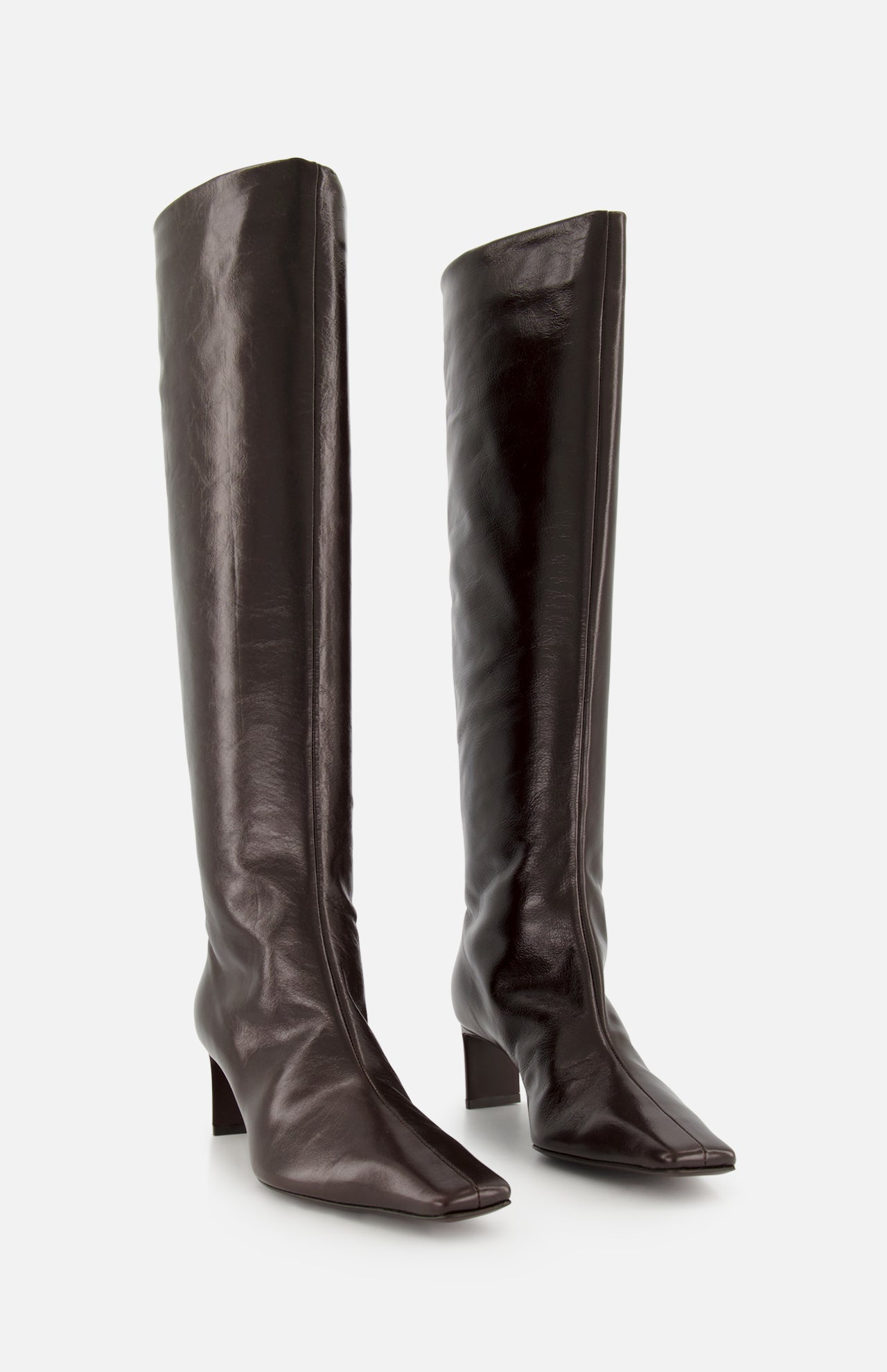 The Ona Knee High Boot by KHAITE is a pair of tall, dark brown leather boots featuring square toes and low block heels, expertly crafted in Italy and standing upright on a plain light background.