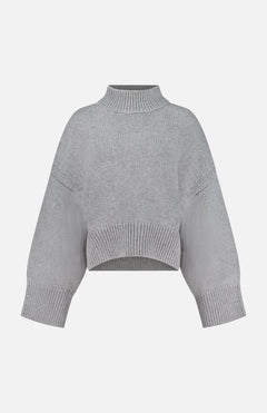 The Phelps Cashmere Sweater by KHAITE—a light gray, long-sleeve cropped knit—features a ribbed mock neck, cuffs, and hem, making it an ideal choice for a minimalist wardrobe. Displayed against a plain white background.
