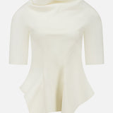 The Pippa Peplum Top by KHAITE features a cream Italian wool suiting with a draped funnel neckline and asymmetrical sculpted hemline, set against a plain background.