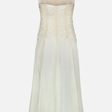 KHAITE Raina Ruched Midi Dress in off-white silk charmeuse features thin spaghetti straps, a ruched bodice, and a subtle A-line skirt, shown against a plain white background.