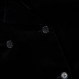 Close-up of the Rolon Velvet Coat by KHAITE—a long black cotton velvet coat featuring a double-breasted design with four black buttons and a visible KHAITE label inside the collar. A timeless addition to any minimalist wardrobe.