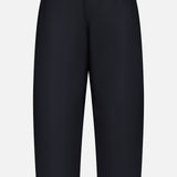 The KHAITE Roma Cropped Pull-on Pant is a pair of plain black, loose-fitting pants made from lightweight wool suiting with an elastic waistband and no visible pockets, shown on a white background.