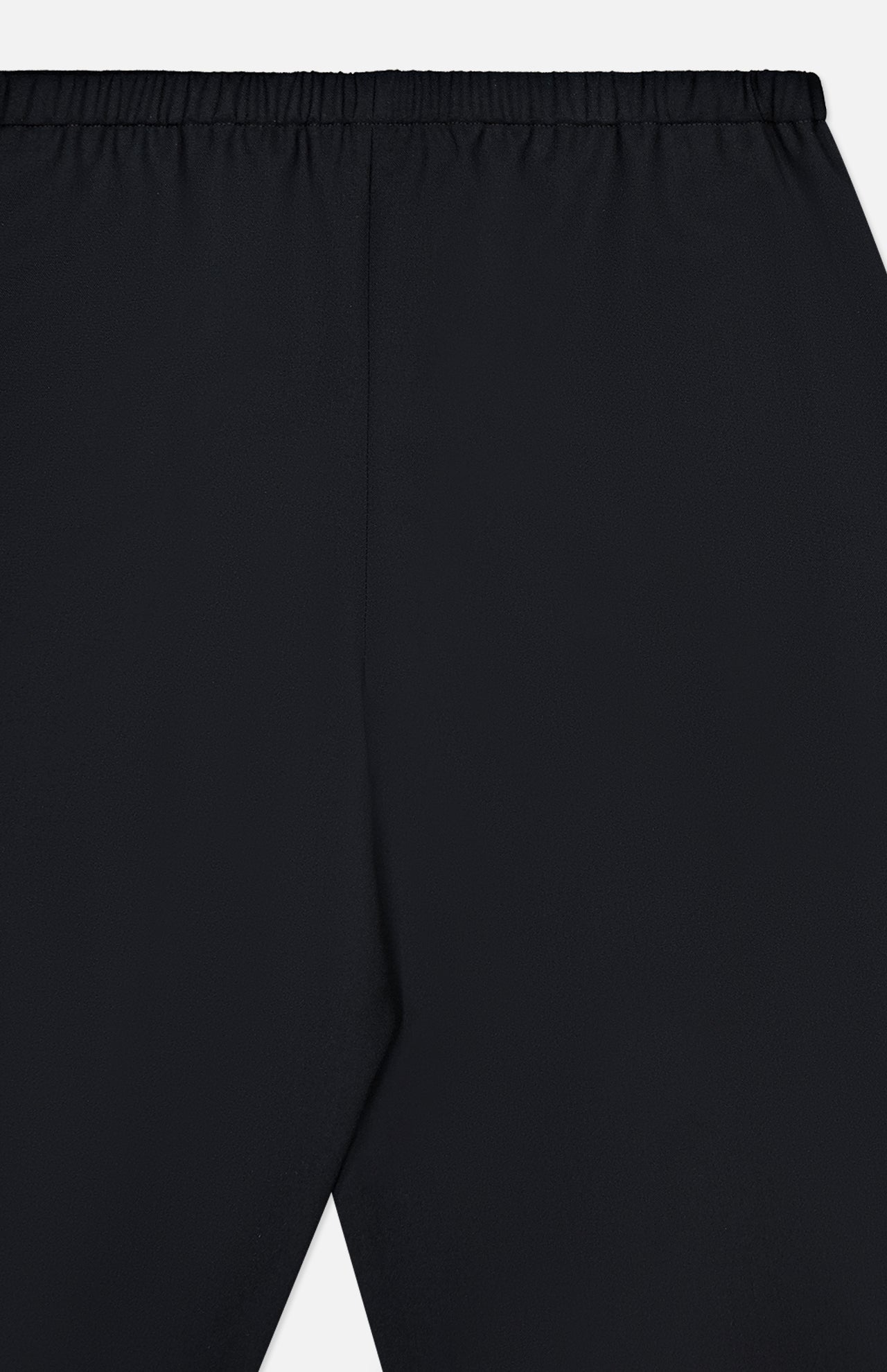 Close-up of the KHAITE Roma Cropped Pull-on Pant, showcasing its black lightweight wool suiting, elastic waistband, smooth texture, and minimal design. Image is cropped to highlight only the upper section of the pants.