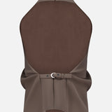 The Rone Open Back Halter Top by KHAITE is a sleeveless brown double-faced crepe piece with a high neckline, asymmetrical hem, back zipper, gathered open back, and wide waist belt with silver buckle.