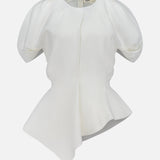 The Rumi Asymmetric Hem Top by KHAITE is a white short-sleeve blouse featuring puffed shoulders, a fitted waist, and an asymmetric hem. Crafted from a luxurious linen-viscose-silk blend, this draped top is displayed on a plain white background.