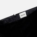 Close-up of the waistband on the Ryden Velvet Pant by KHAITE, showcasing a visible zipper and a white fabric label with the brand name stitched inside. The high-rise silhouette and lush velvet texture highlight its Italian craftsmanship.