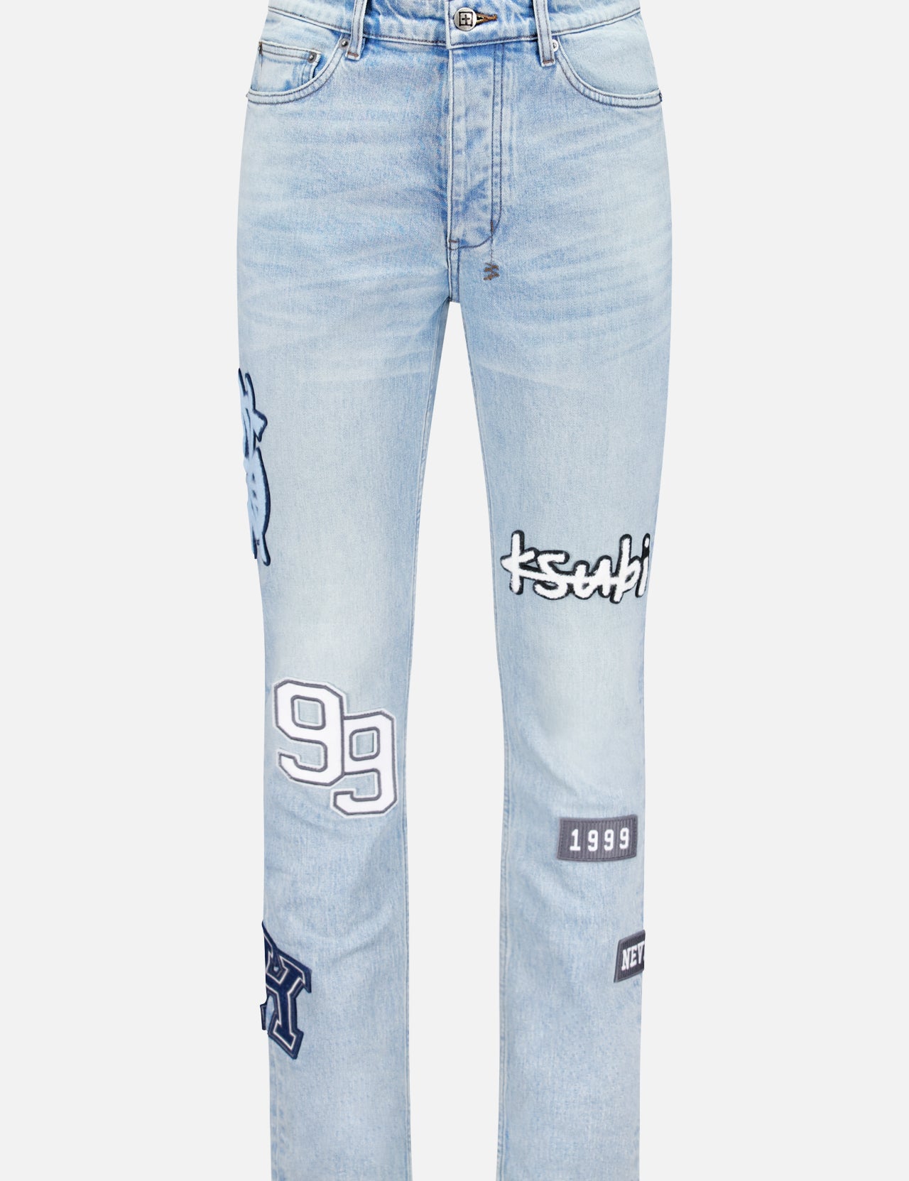 KSUBI Chitch Striker Patched Slim Jeans in light blue feature a high waist, straight legs, and multiple black and white embroidered patches—numbers, letters, and logos—stitched on the front.