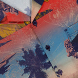 A close-up of the KSUBI Mauna Loa Short Sleeve Diner Shirt in size M, showcasing its vibrant tropical sunset print with palm trees, ocean waves, and sailboats. Made from soft cotton modal fabric; brand and size appear on the shirt tag.