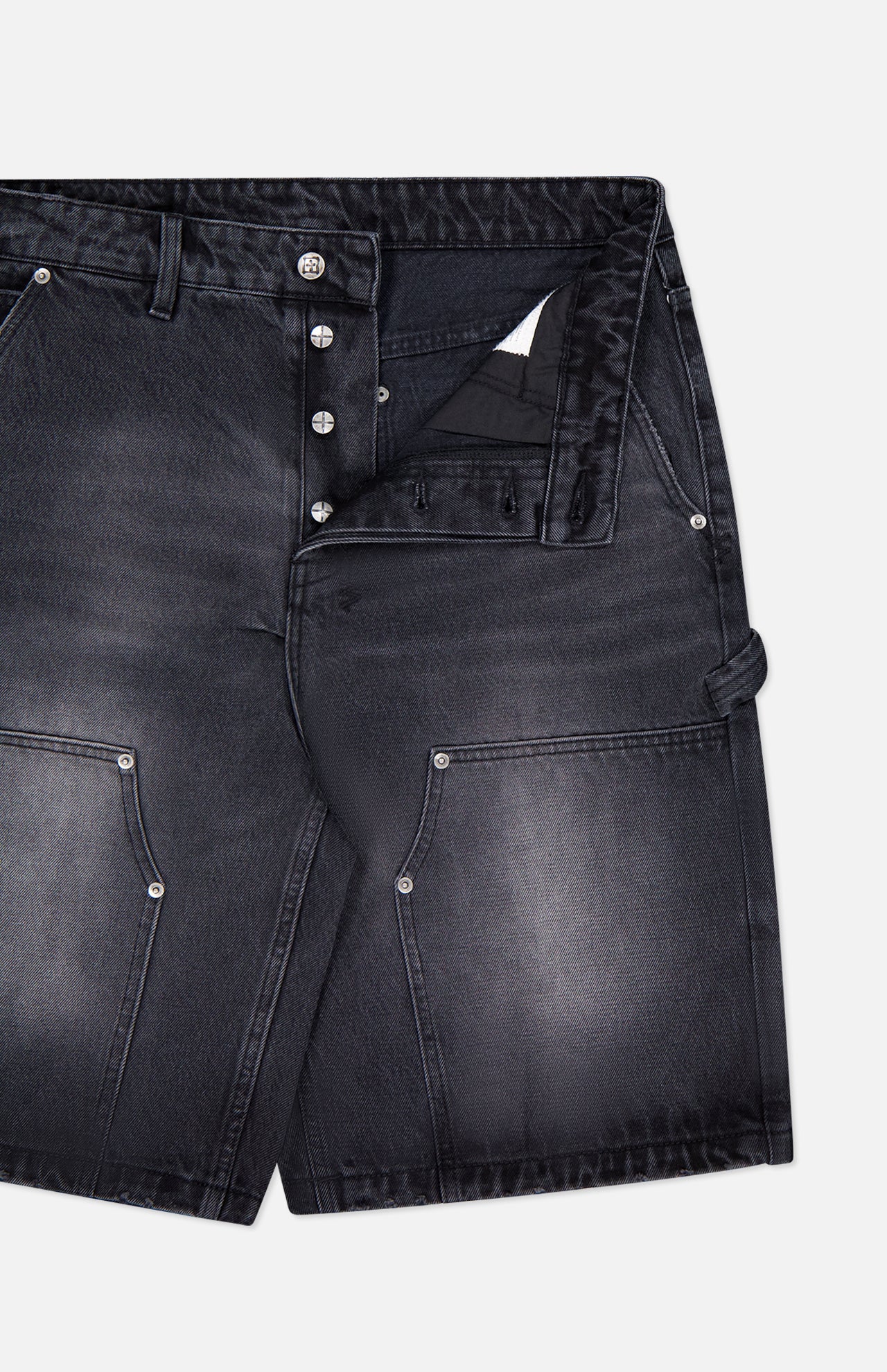 KSUBI Maxx Operator Jean Shorts in black denim with a faded wash, wide leg fit, large carpenter pockets, silver rivets, belt loops, and an exposed button fly (top button fastened), displayed on a white background.