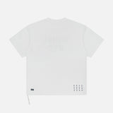 The KSUBI NYC Ekcess Short Sleeve T-shirt is an oversized white tee in premium cotton jersey, featuring a faint NYC logo on the back, small perforated dots, and a square patch near the lower hem.