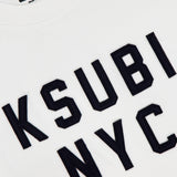 Close-up of the KSUBI NYC Ekcess Short Sleeve T-shirt in white premium cotton jersey, featuring bold black NYC logo artwork on the front and a collar tag with the KSUBI brand name.