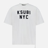 The KSUBI NYC Ekcess Short Sleeve T-shirt is an oversized white cotton jersey tee with bold black NYC logo artwork on the front, featuring a loose fit and high crew neckline for effortless style.