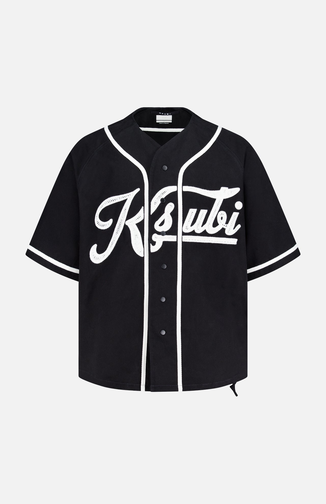 The KSUBI Outfield Short Sleeve Jersey Top is a black oversized-fit jersey featuring white trim, snap buttons, and bold white Ksubi script on the front for a sporty, standout look.
