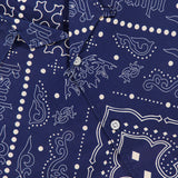 Close-up of the KSUBI Paise Diner Short Sleeve Shirt in navy blue, showcasing white paisley and geometric bandana prints, a Cuban collar with buttons, and a visible KSUBI label near the collar.