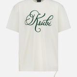 The KSUBI Prestige Biggie Short Sleeve T-shirt in antique white is made from premium cotton jersey and features large green cursive "Ksubi" lettering on the chest with a drawstring detail at the lower right side.