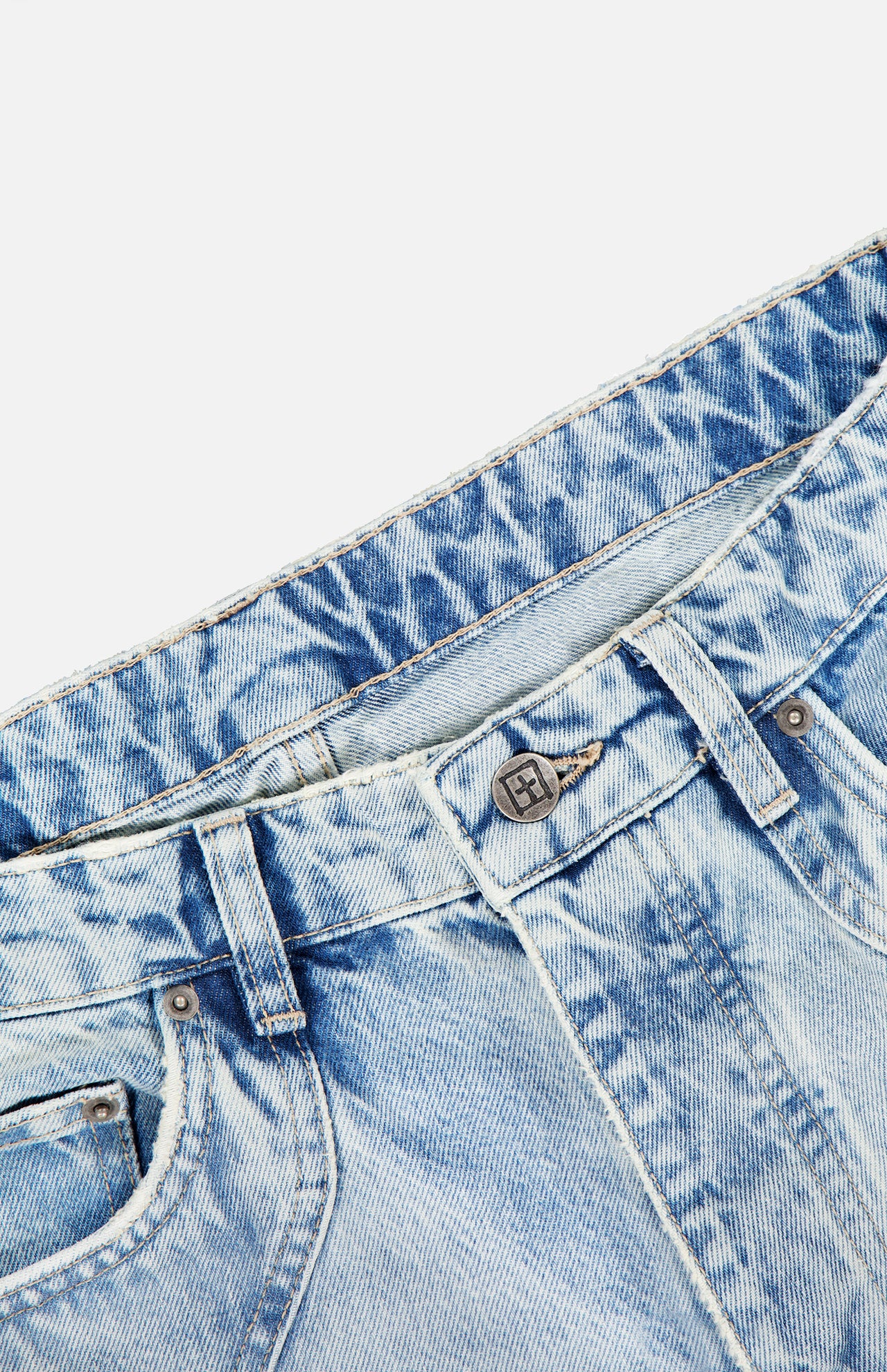 Close-up of the waistband and top front section of the KSUBI Toro Western Knee Paneling Jeans in light blue acid-wash embroidered denim, showing pockets, belt loops, button, and part of the zipper.