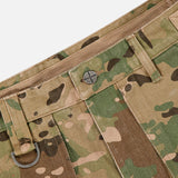 A close-up of the KSUBI Trooper Camouflage Cargo Pant waistband highlights woodland camo, a metal button, belt loops, a D-ring, and herringbone weave texture.