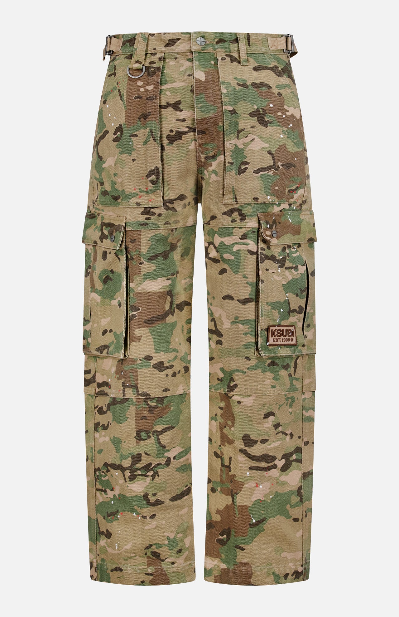 The KSUBI Trooper Camouflage Cargo Pant features a green and brown woodland camo, relaxed leg, multiple pockets including large zippered sides, metal D-rings, and a KSUBI logo patch on the right pocket.