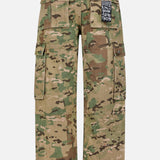 The KSUBI Trooper Camouflage Cargo Pant is shown from the back in green, brown, and beige tones, featuring multiple large pockets and a black-and-white text patch on the right back pocket with a relaxed leg fit.